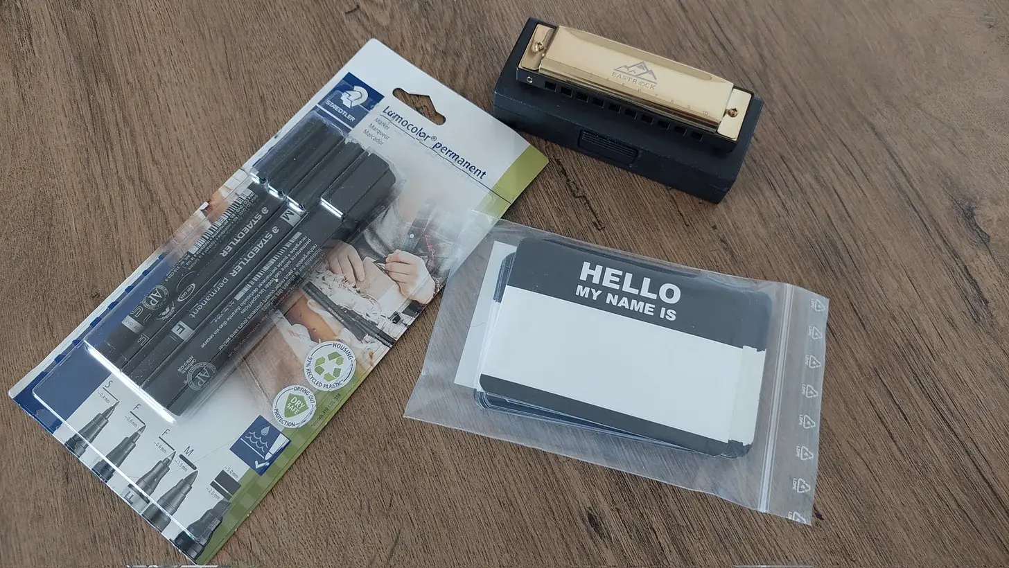 Name tags, markers, and a harmonica laid out for the cocktail party
