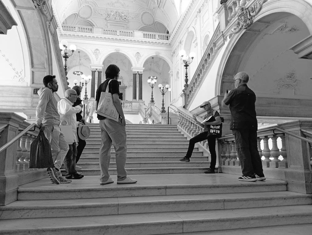 Black-and-white photo of the group on a grand staircase during the City of Ideas walking tour in Vienna